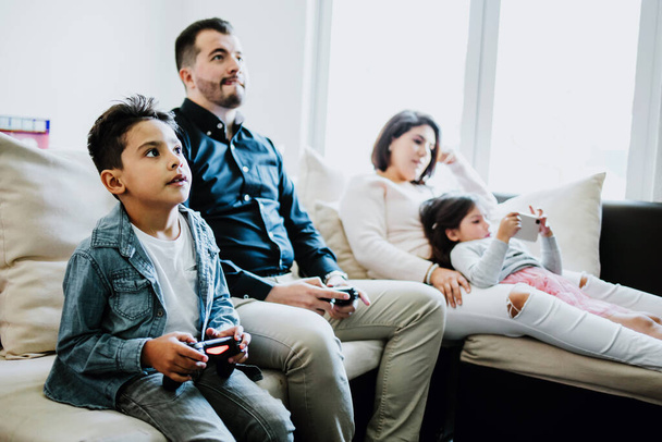 Latin baba ve oğlu video oyunları oynuyor ve Meksika 'da kendi evlerinde birbirleriyle yarışıyorlar. - Fotoğraf, Görsel