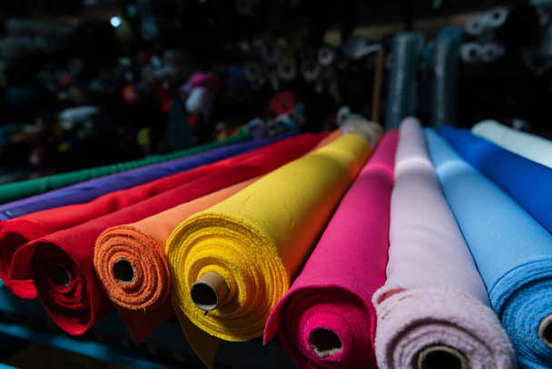 Interior of an industrial warehouse with fabric rolls samples. Small business textile colorful warehouse. High quality photo - 写真・画像