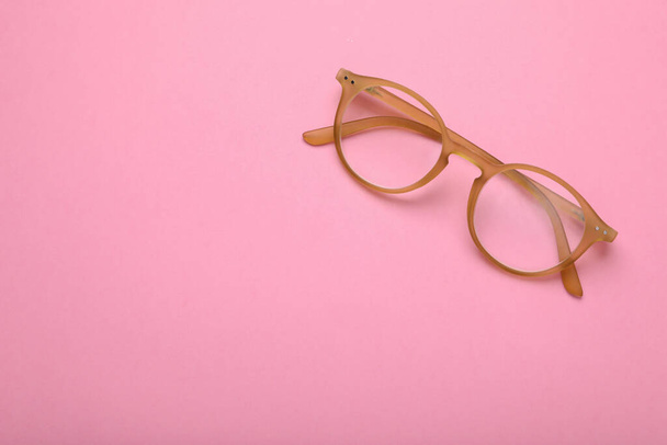 Glasses with corrective lenses on pink background, top view. Space for text - Fotoğraf, Görsel