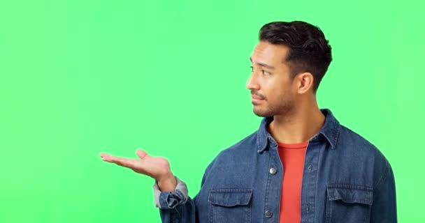 Face, pointing and man in a studio with green screen for advertising, marketing or product placement. Happy, smile and portrait of an Indian male model showing mockup space by a chroma key background. - Footage, Video