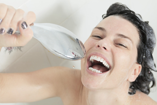 Shower woman. Happy smiling woman washing shoulder showering in - 写真・画像