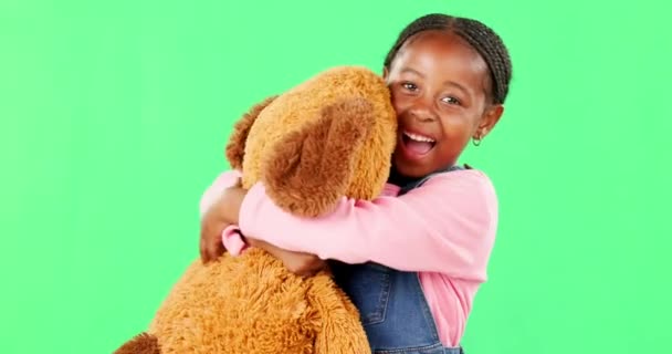 Tela verde, amor e uma menina negra abraçando seu ursinho de pelúcia no estúdio em emoção ou conforto. Retrato, feliz e abraço com uma criança adorável fêmea segurando seu animal de pelúcia no chromakey. - Filmagem, Vídeo