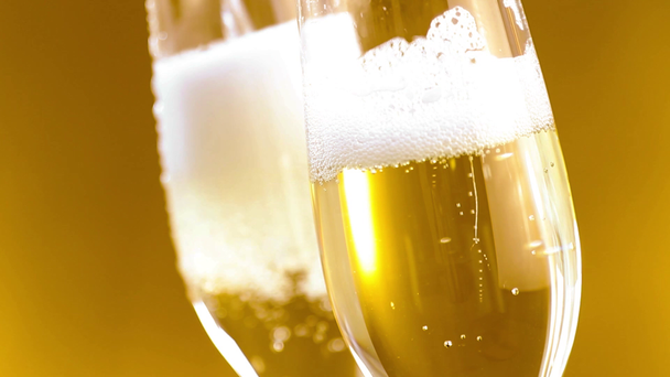 Flety szampana z złoty pęcherzyki na złotym tle - Materiał filmowy, wideo