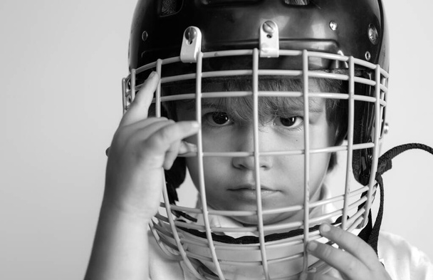 Hockey or rugby helmet. Sport childhood. Future sport star. Sport upbringing and career. Boy cute child wear hockey helmet close up. Safety and protection. Protective grid on face. Sport equipment. - Foto, Bild