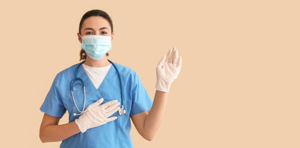 Female medical assistant on beige background with space for text - Fotó, kép