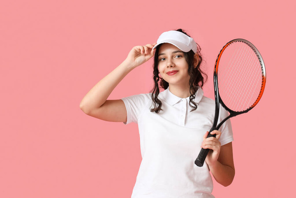 十代のテニス選手とともにラケットオンピンクの背景 - 写真・画像
