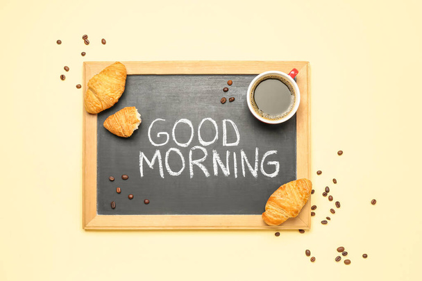 Chalkboard with text GOOD MORNING, cup of coffee, beans and croissants on color background - Foto, immagini