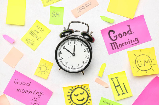 Composition with alarm clock and different sticky notes on light background - Photo, Image