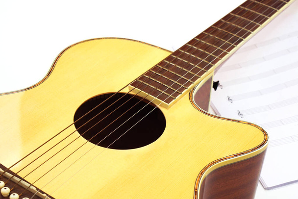 Guitarra acústica con notas musicales sobre fondo blanco. Entretenimiento, amor y concepto musical. - Foto, Imagen