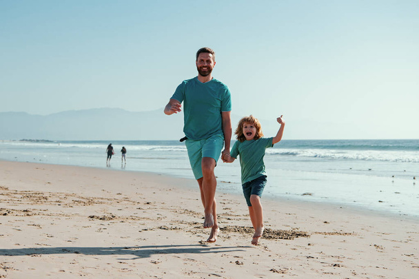 Father and son running on summer beach. Family travel, vacation, fathers day concept - Zdjęcie, obraz
