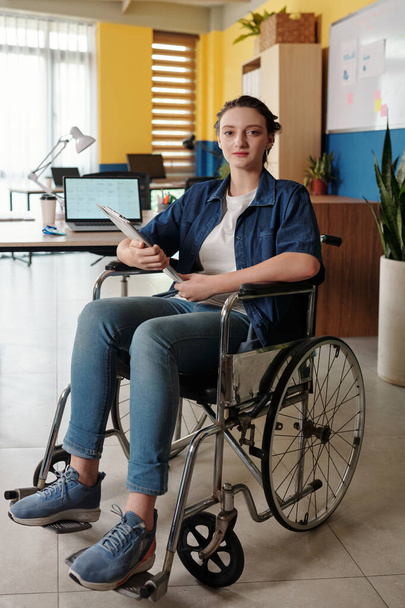 Portrait of young woman with disability working in office - 写真・画像