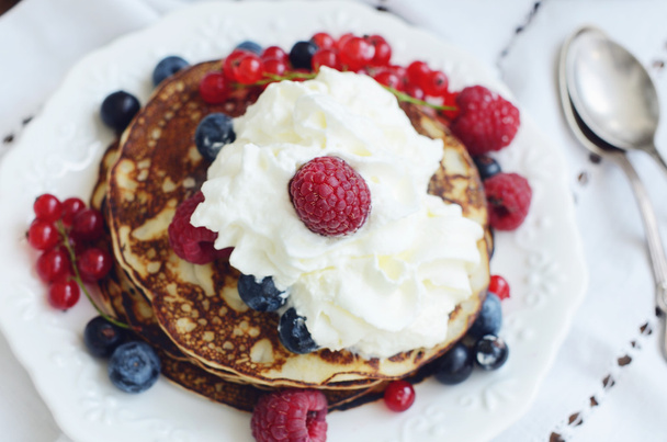 Homemade thin pancakes with whipped cream and fresh berries - Fotó, kép