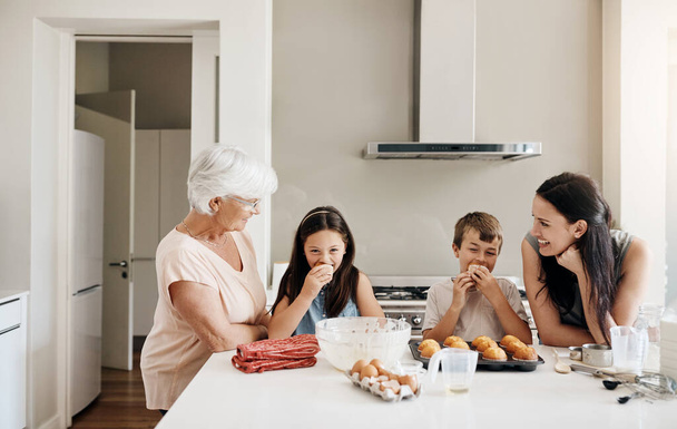 Тест на смак найкраща частина. щаслива сім'я трьох поколінь випічки кексів разом вдома
 - Фото, зображення