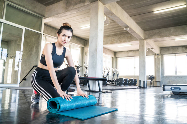 Sport asian woman with yoga mat in fitness gym healthy lifestyle - Photo, Image