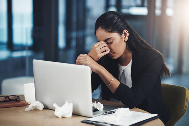 And now a headache too on top of it all. a young businesswoman suffering with a headache while working in an office - Fotó, kép