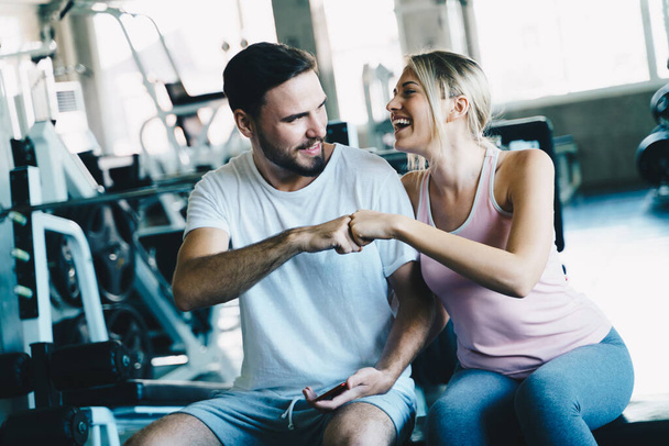 Slimme sport man en vrouw uit te werken in fitnessruimte gezonde levensstijl - Foto, afbeelding