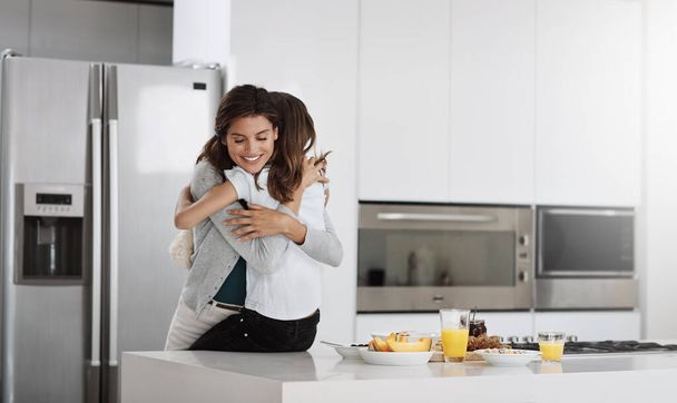 Maminka tě miluje. atraktivní mladá žena a její dcera objímání při trávení času spolu doma - Fotografie, Obrázek
