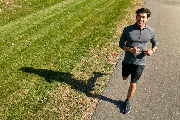 Mieti, montako palkintoa jahtaat. urheilullinen nuori mies juoksee ulkona - Valokuva, kuva