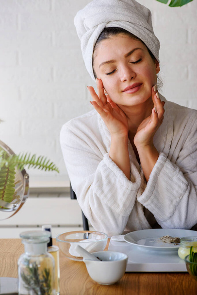 bella giovane donna con asciugamano sulla testa rendendo routine quotidiana la cura della pelle - Foto, immagini