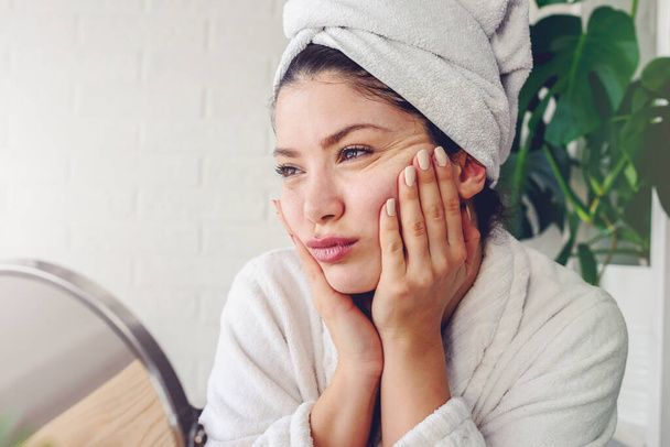 beautiful young woman with towel on her head making daily skin care routine - Фото, зображення