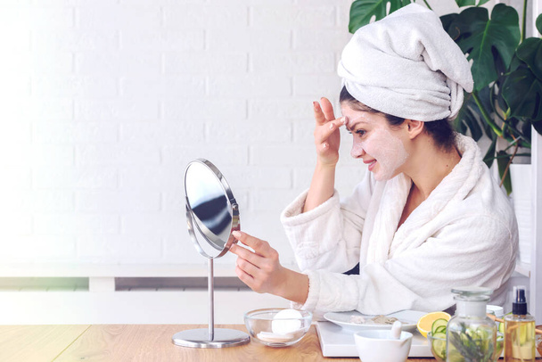 beautiful young woman with towel on her head making daily skin care routine - Photo, Image