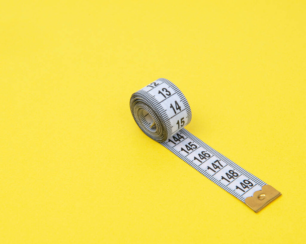 white tape measuring isolated on a yellow background - Фото, зображення
