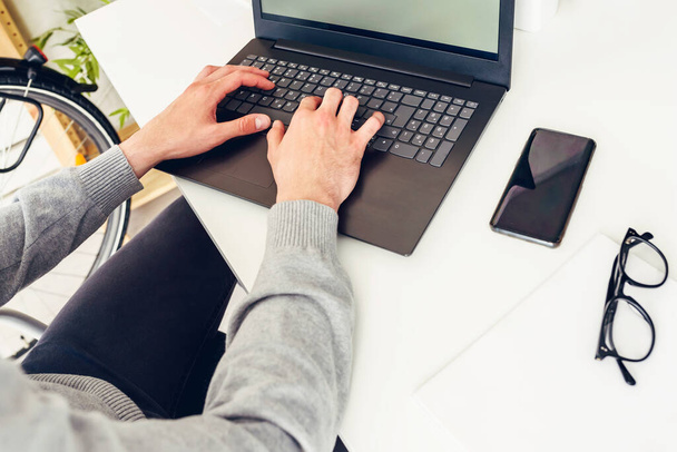 view of businessman using laptop,typing in office - Fotó, kép