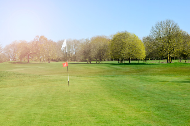 Uvedení zelené na golfovém hřišti za slunečného dne s výhledem na plavební dráhu - Fotografie, Obrázek
