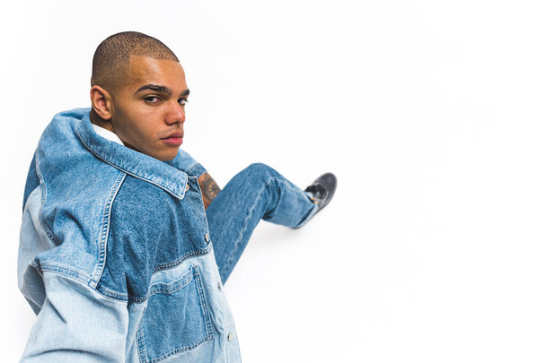 African American male model wearing full denim outfit looking back at the camera on white background . High quality photo - Fotó, kép