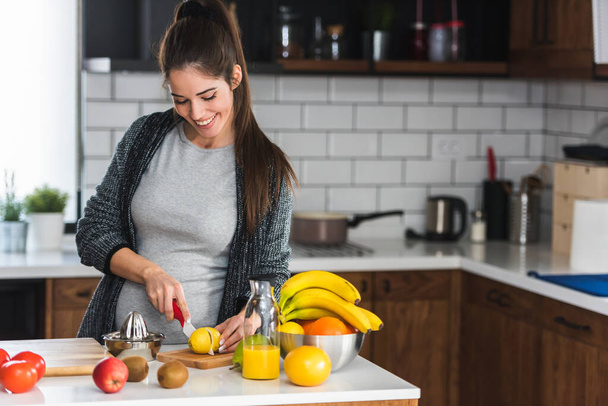 Kadın mutfakta meyve kesiyor, sağlıklı gıda konsepti.  - Fotoğraf, Görsel
