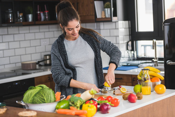 キッチンで果物を切る女性、健康的な食べ物の概念  - 写真・画像