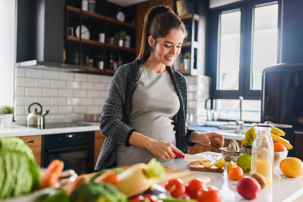 Frau schneidet Gemüse und Obst in der Küche, gesundes Ernährungskonzept  - Foto, Bild