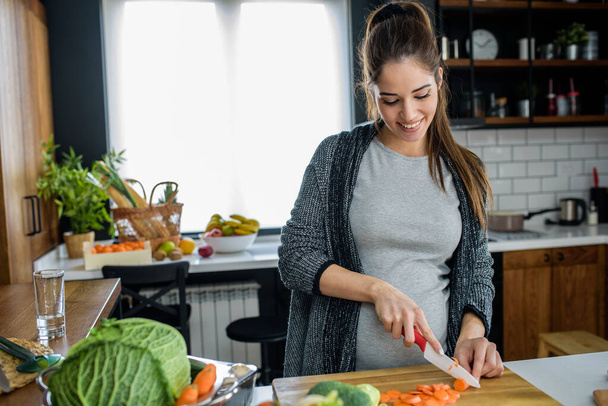 nő vágás zöldségek és gyümölcsök a konyhában, egészséges étel koncepció  - Fotó, kép