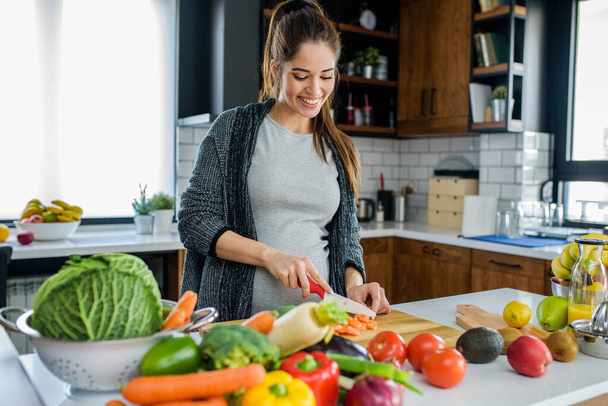 woman cutting vegetables and fruits in kitchen, healthy food concept  - Photo, Image