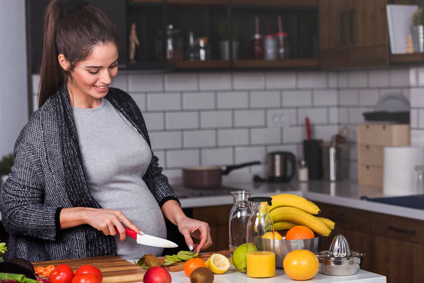 женщина режет овощи и фрукты на кухне, концепция здорового питания  - Фото, изображение