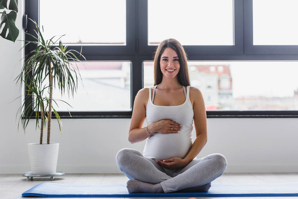 Mujer embarazada haciendo ejercicio en el gimnasio
 - Foto, imagen