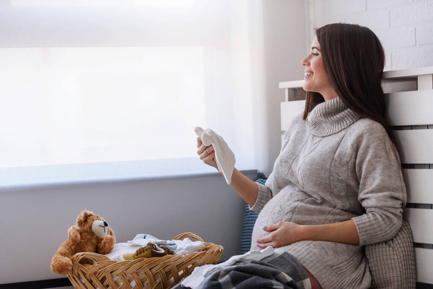 jeune femme enceinte avec buanderie à la maison - Photo, image