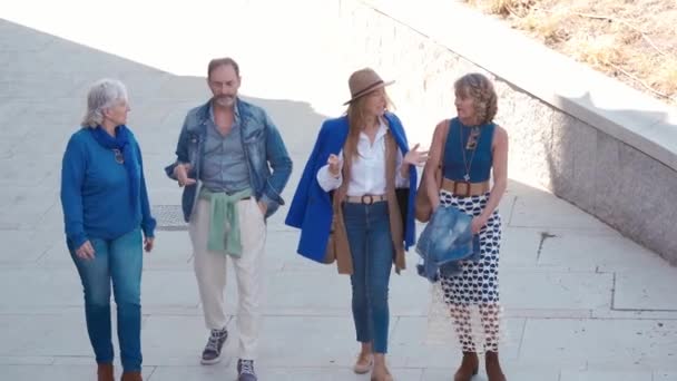 Bir grup mutlu kıdemli arkadaş şehirde yürüyor, gülüyorlar. Yüksek kalite 4k görüntü - Video, Çekim
