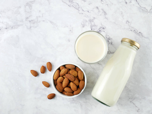 Almonds with milk on marble texture background. - Zdjęcie, obraz