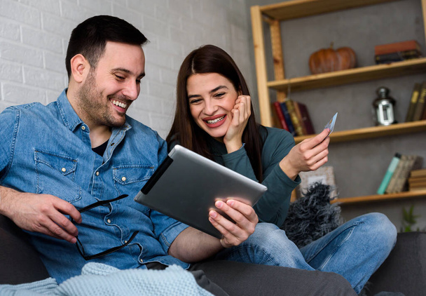 幸せなカップルは家でオンライン注文をして買い物のコンセプトを - 写真・画像