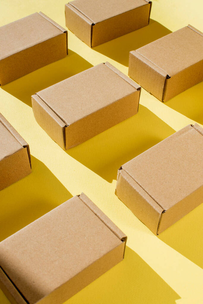 Many cardboard kraft boxes on a yellow background. Packing the parcel - Fotó, kép