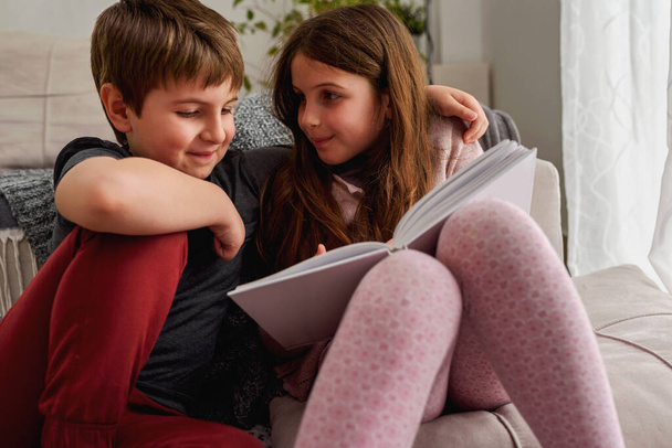 pieni poika ja tyttö lukeminen kirja kotona  - Valokuva, kuva