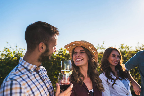 barátok bort isznak a szőlőskertben - Fotó, kép