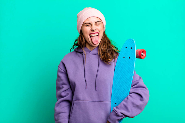 hispanic pretty woman with cheerful and rebellious attitude, joking and sticking tongue out. skate boarding concept - Foto, imagen
