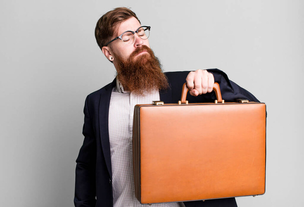 young adult red hair bearded cool businessman with a leather suitcase - Foto, immagini