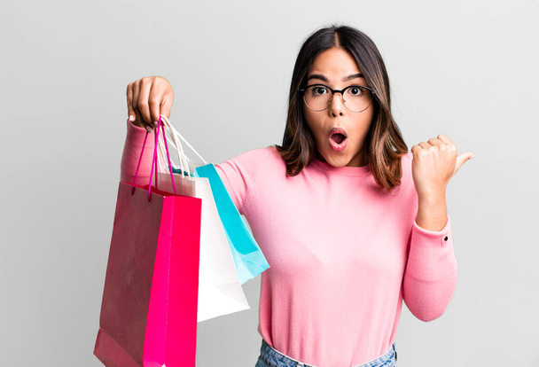 hispanic pretty woman looking astonished in disbelief. shopping concept - Photo, Image