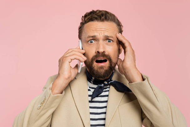 shocked french man in blazer and neck scarf talking on smartphone isolated on pink  - Фото, зображення