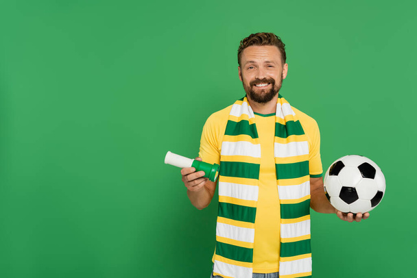 szczęśliwy fan piłki nożnej gospodarstwa sportowe róg i piłka nożna izolowane na zielono  - Zdjęcie, obraz