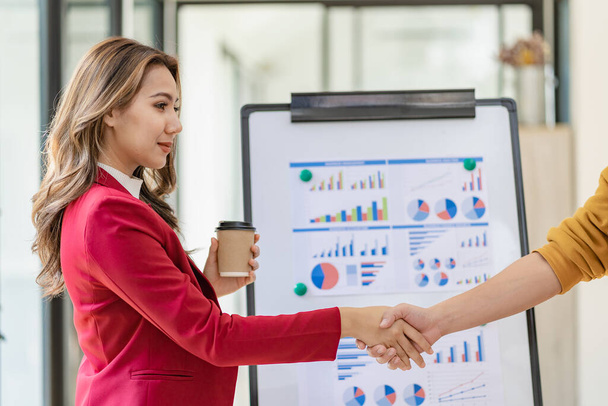 Businesswoman shaking hands and smiling while standing in modern office partner cooperation, colleague teamwork concept - Photo, Image