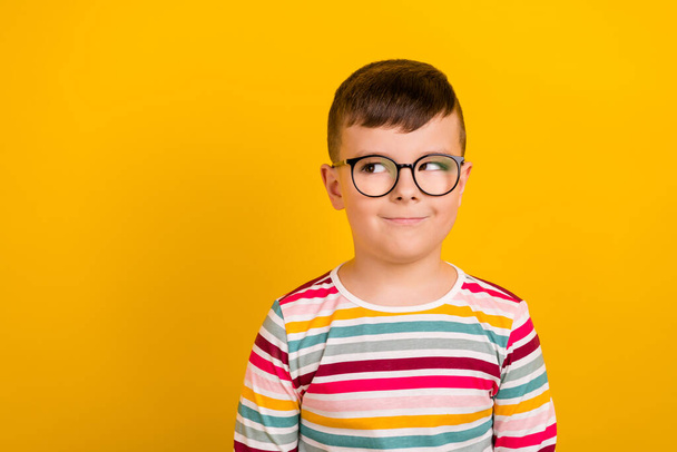 Photo of positive boy wear striped stylish clothes interested look empty space school supplies isolated on yellow color background. - Φωτογραφία, εικόνα